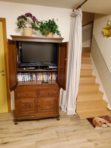 a television on a wooden stand in a room with stairs at Holiday Home IRENE in Lilo
