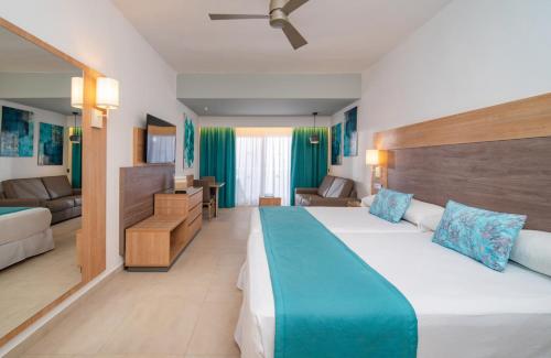 a hotel room with a large bed and a couch at Riu Palace Tropical Bay - All Inclusive in Negril