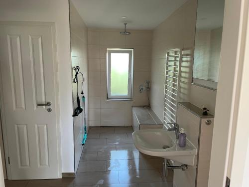 a white bathroom with a sink and a mirror at Quartier Usedom in Ostseebad Karlshagen