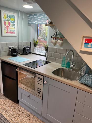 a kitchen with a sink and a counter top at Tiny Beach House in Saint Annes on the Sea