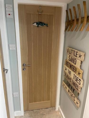 a door in a hallway with a sign on the wall at Tiny Beach House in Saint Annes on the Sea