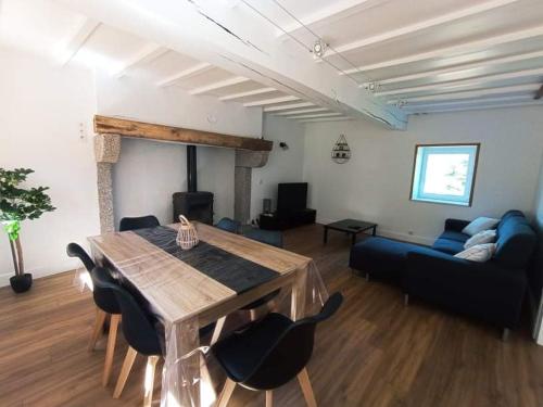 a living room with a table and a blue couch at Gîte Les Hauts de Villemaloux in Dontreix