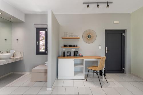 a bathroom with a desk and a sink at Minois Boutique Hotel in Stalida