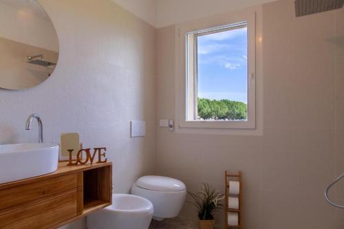 une salle de bain avec un lavabo et des toilettes et une fenêtre dans l'établissement Villa Emilia, à San Giovanni in Marignano