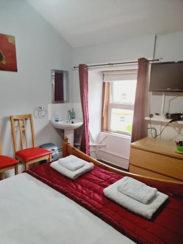 a bedroom with a bed with two towels on it at Dalry Guesthouse in Edinburgh