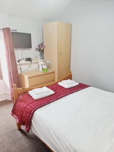 
a bedroom with a bed and a dresser at Dalry Guesthouse in Edinburgh
