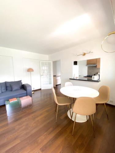 un salon avec un canapé bleu, une table et des chaises dans l'établissement Superb Apartment In Cannes With Magnificent View !, à Cannes