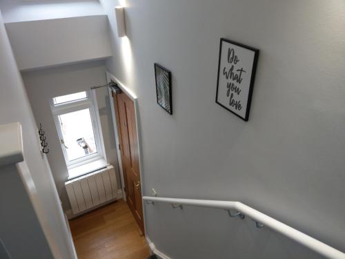a hallway with a staircase with a door and a window at 27 High Street Apartments in Husbands Bosworth