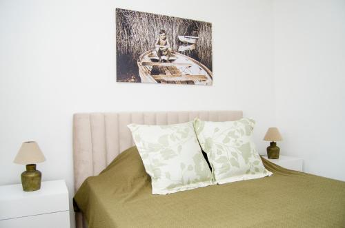 a bedroom with a bed and a picture on the wall at South Part Zamárdi in Zamárdi