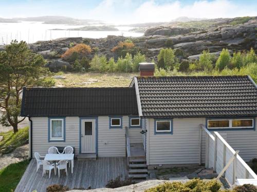 a small house with a table and chairs on a deck at 6 person holiday home in Bovallstrand in Bovallstrand