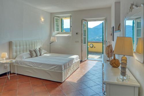 a bedroom with a bed and a balcony at Villa dell'Erta - Levanto in Montale