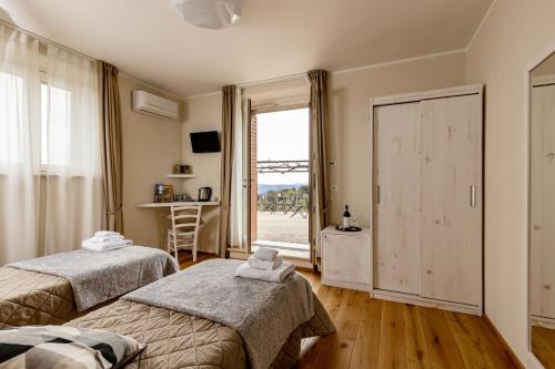 a bedroom with two beds and a window at Podere Belsogno in Montalcino