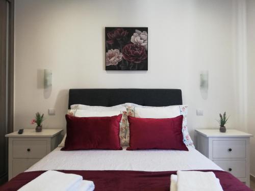 a bedroom with a large bed with red pillows at Amoreira Mar, Alvor - Praia e Piscina in Alvor