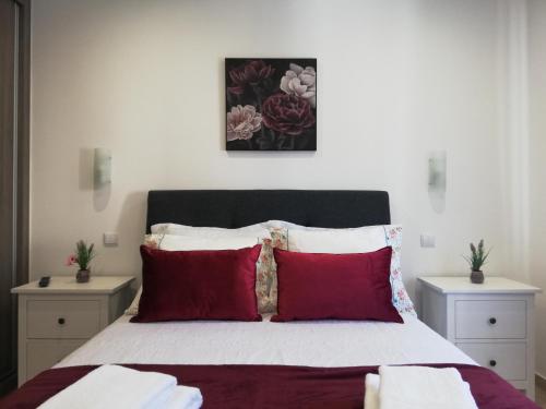 - une chambre avec un grand lit et des oreillers rouges dans l'établissement Amoreira Mar, Alvor - Praia e Piscina, à Alvor