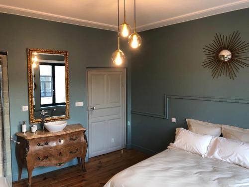 een slaapkamer met een bed, een wastafel en een spiegel bij Les chambres Berguoises Chambre au coeur de Bergues in Bergues