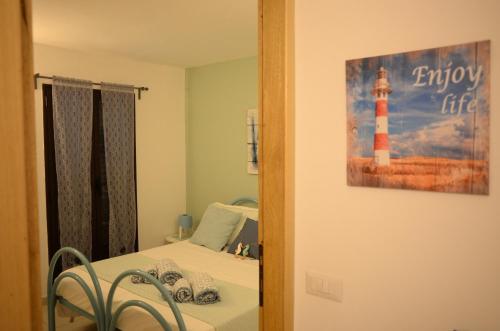 a reflection of a room with a bed and a lighthouse at Villa Sangemi in Àrbatax