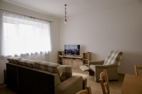 a living room with a couch and chairs and a tv at Apartment Žacléř - 3BR, Kitchen & Living Room in Žacléř