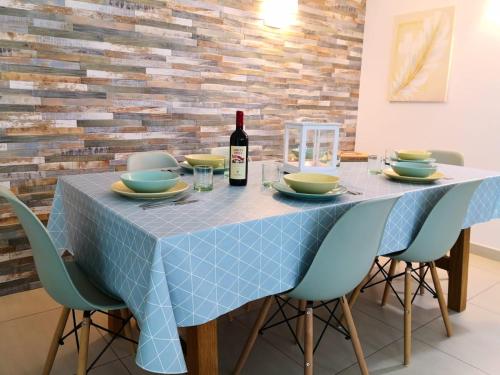 a table with a blue table cloth and a bottle of wine at Villa Sangemi in Àrbatax