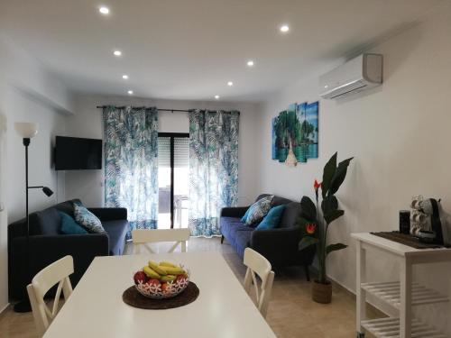 a living room with a table with a bowl of bananas on it at Amoreira Mar, Alvor - Praia e Piscina in Alvor