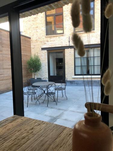 d'une terrasse avec une table, des chaises, une table et des chaises. dans l'établissement Les chambres Berguoises Chambre privée au Cœur de Bergues, à Bergues