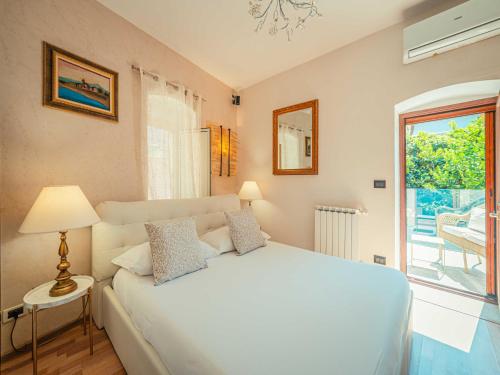 a bedroom with a white bed and a window at Villa al Duomo in Taormina