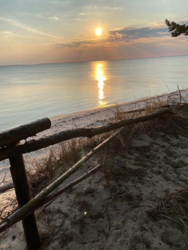 puesta de sol en la playa con una valla de madera en Przyczepa Abordaż na Campingu Kormoran en Hel