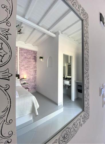 a mirror in a white room with a bedroom at Apsenti couples only in Agios Ioannis Mykonos