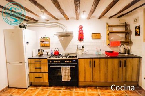 a kitchen with a black stove and a refrigerator at Calle Horno in Castril