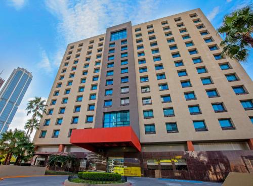 a large building with a red awning in front of it at CHN Hotel Monterrey Centro, Trademark Collection by Wyndham in Monterrey