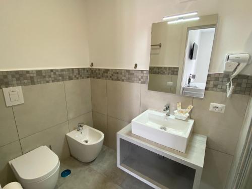 a bathroom with a sink and a toilet and a mirror at InVilla Bed&Breakfast - Quality Rooms in Santa Maria di Castellabate
