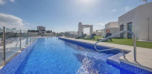 a large swimming pool with blue water on a building at ESTUPENDO APARTAMENTO ENTERO in Marbella