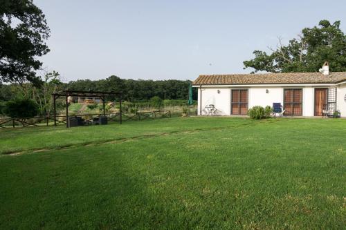 una pequeña casa blanca con un gran patio en Agriturismo il Poggio, en Vetralla
