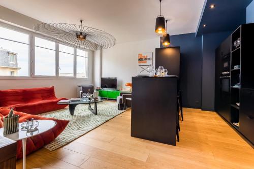 un salon avec un canapé rouge et une table dans l'établissement CATWALK KEYWEEK 2 bedroom apartment in Biarritz city center parking, à Biarritz