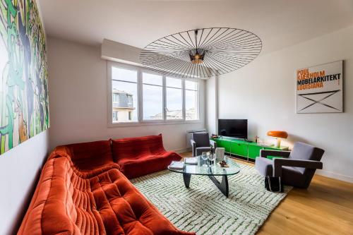 un salon avec un canapé rouge et une table dans l'établissement CATWALK KEYWEEK 2 bedroom apartment in Biarritz city center parking, à Biarritz