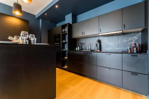une grande cuisine avec des armoires noires et un comptoir dans l'établissement CATWALK KEYWEEK 2 bedroom apartment in Biarritz city center parking, à Biarritz