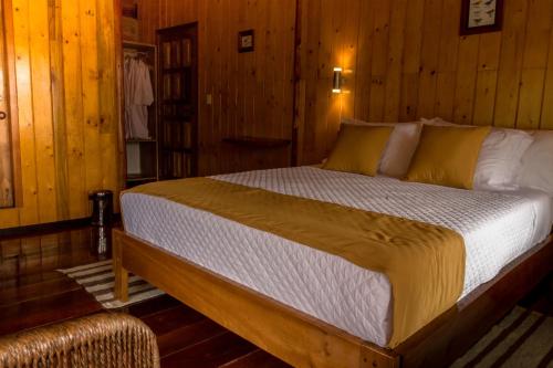 a bedroom with a bed in a wooden room at Casa de Vista Alta in Mindo