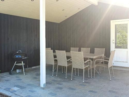 un patio con mesa, sillas y parrilla en 4 person holiday home in Gilleleje, en Gilleleje