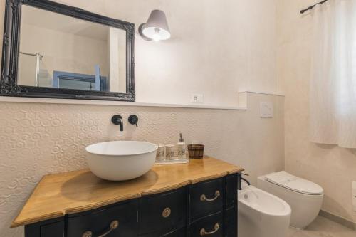 a bathroom with a sink and a toilet and a mirror at B&B Antico Telaio in Santa Maria Navarrese