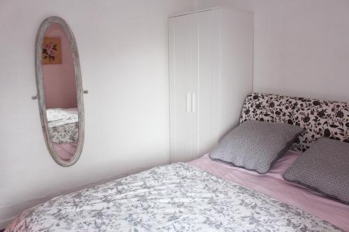 a small bedroom with a bed and a mirror at Ce Petit Chemin in Cenves