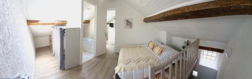 een witte slaapkamer met een bed en een trap bij Charmante Maison Cosy à Villabé-Hyper Centre-Gare-WIFI in Villabé