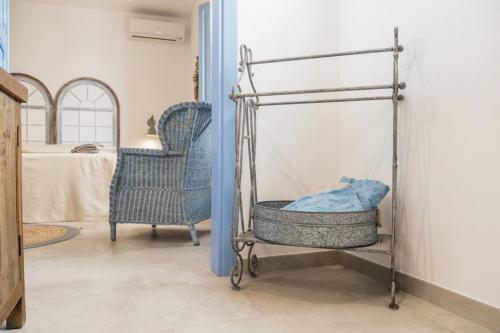 a room with two blue chairs and a bed at B&B Antico Telaio in Santa Maria Navarrese