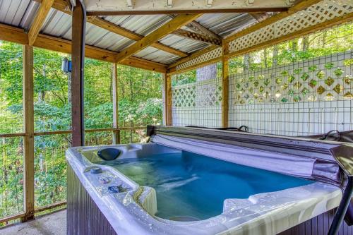 a jacuzzi tub in a room with windows at Three Bears Den, Hot Tub, Pool table, Pool Access, 560 FREE tickets each paid day in Gatlinburg