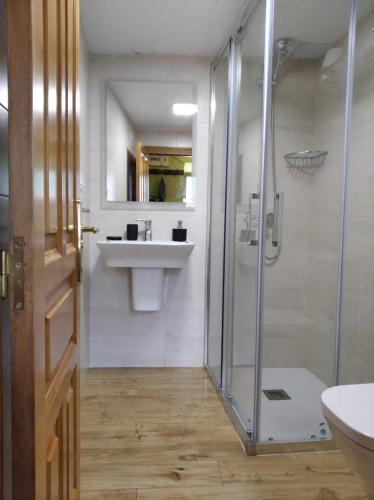 a bathroom with a glass shower and a sink at La Xiana in Taranes