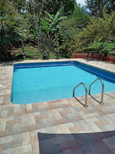 a swimming pool with blue water in a yard at Agradable casa de Campo Villa Maruja. in Palmira