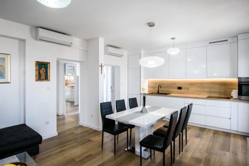 a kitchen and dining room with a table and chairs at Aurora Seaview Apartment in Mlini