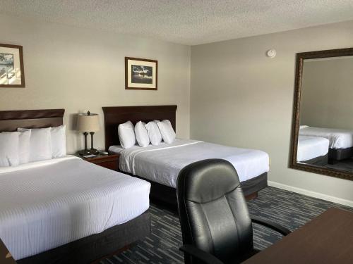 a hotel room with two beds and a mirror at Park Lane Motel in Lake George