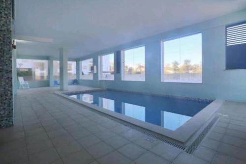 a large swimming pool in a building with windows at LAGOS APARTMENT in Lagos