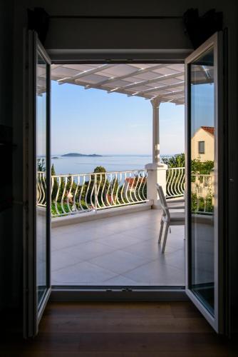 a balcony with a chair and a view of the ocean at Aurora Seaview Apartment in Mlini