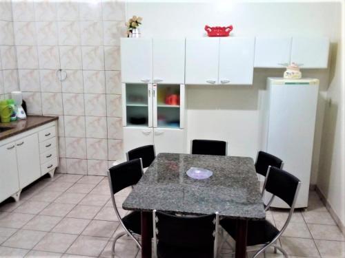 a kitchen with a table with chairs and a refrigerator at Jardim de Londres - Sobrado em Campinas in Campinas