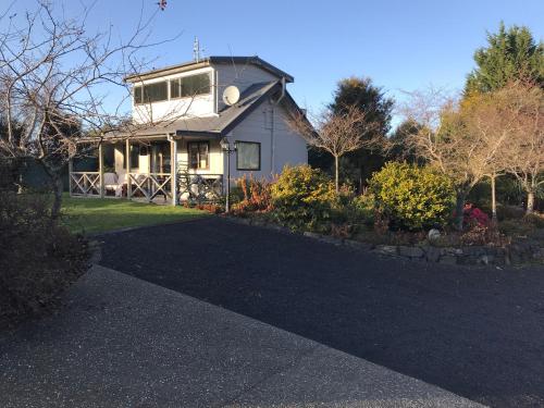 a house with a driveway in front of it at Pet Friendly Country Cottage in Dunedin